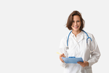 Poster - Beautiful female doctor with clipboard on white background