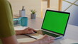 © stockbusters - Remote manager looking green screen laptop at cozy home workplace closeup.