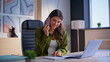 © stockbusters - Businesswoman making order smartphone call sitting office with laptop closeup