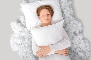 Wall Mural - Handsome young happy man in pajamas with pillow and filling lying on grey background, top view