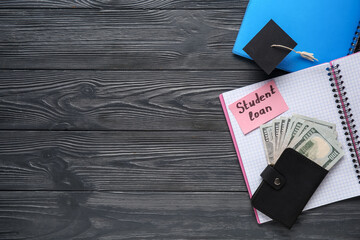 Wall Mural - Paper sheet with text STUDENT LOAN, notebooks, money and small graduation hat on dark wooden background