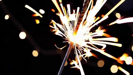Poster - Close-up of a sparkling sparkler against a dark background, celebrating festive moments with bright light. Joy and celebration concept
