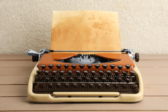 Vintage typewriter with parchment paper on wooden table
