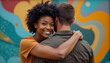© rachid - a man and woman embracing each other in front of a colorful wall