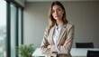 © schiers_images - Confident professional woman in elegant attire standing with arms crossed in a modern office. Represents leadership, success, and ambition in a corporate environment.