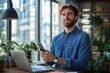 © Aleksandra - Young Smiling Man Working in Modern Office Holding Smartphone and Using Laptop