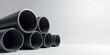 © vattana - A Collection of Dark Cylindrical Pipes Arranged in a Stack Against a Neutral Background