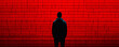 © Anatthaphon - Silhouette of person against red digital screen with horizontal lines, representing technology and anonymity.