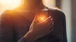 © Nhoeb - Heart Symbol Illuminated in Hands of a Person with Soft Glow