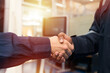 © amorn - Hands of male engineer handshake together in workshop room of building. Successful, Unity and teamwork, Finished and completed work concept