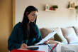 © alvaro - Young woman managing home finances and calculating expenses at home
