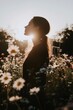 © Natalia Nechyporuk - Woman enjoying the sunset in a field of daisies, breathing fresh air and connecting with nature