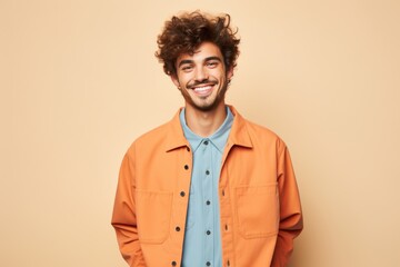 Wall Mural - A man in an orange jacket is smiling and posing for a picture