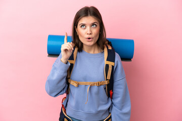 Wall Mural - Young mountaineer woman with a big backpack isolated on pink background intending to realizes the solution while lifting a finger up