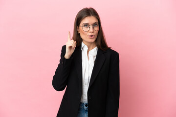 Wall Mural - Young Business caucasian woman isolated on pink background intending to realizes the solution while lifting a finger up