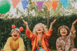 © Lena - three of diverse children dressed as clowns and magicians, performing a playful act in a backyard, with colorful balloons. horizontal retro photograph with noisy. circus performances