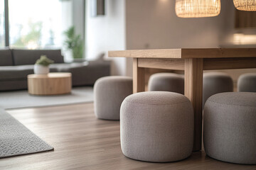 Aufkleber - A cozy modern living room with a wooden dining table, soft poufs, and neutral colors, showcasing a warm and minimalist design that reflects comfort and contemporary style.