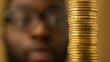 © BoOm - A focused view of a stack of gold coins in front of a person. The image symbolizes wealth, finance, and investment opportunities in the modern economic landscape.