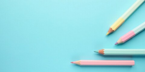Poster - Pastel Colored Pencils Arranged on a Light Blue Background for Art and Design Projects