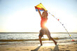 © New Africa - Cute little child with kite running on beach near sea at sunset. Spending time in nature
