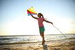 © New Africa - Cute little child playing with kite on beach near sea at sunset. Spending time in nature