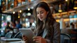© matinee - Young businesswoman in formal suit wearing earphone working with digital tablet at modern cafe.