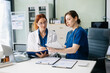 © Nuttapong punna - Doctors and nurses collaborating in a modern medical office, showcasing teamwork and patient care.