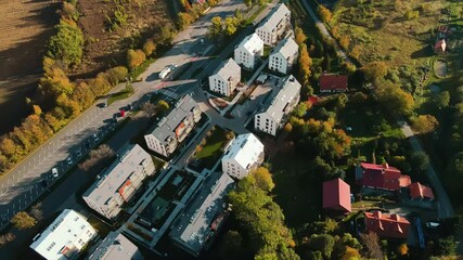 Wall Mural - Aerial view of modern residential neighborhood with contemporary apartment buildings, green spaces, parking areas and well-maintained pathways on sunny day