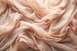 © Urenus Photos - Elegant Draped Peach-Colored Fabric Texture, Showing Soft, Flowing Waves and Subtle Light Reflections