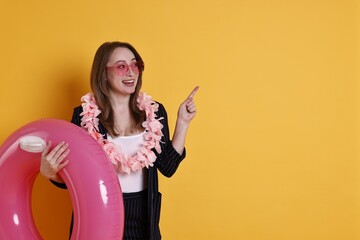 Sticker - Businesswoman with inflatable ring, flower wreath and sunglasses pointing on orange background, space for text