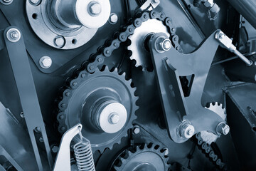 Poster - A close up of a chain drive mechanism. The chain drive is made up of many small gears and is very intricate industrial concept background