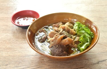 Wall Mural - boiled braised beef meat and tendon couple organ in herb brown soup on bowl dipping spicy chili sauce 