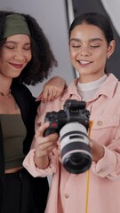 Poster - Happy women, photographer or model with camera for photoshoot, digital content or production at studio. Female people, videographer or client with smile for film industry, process or marketing on set