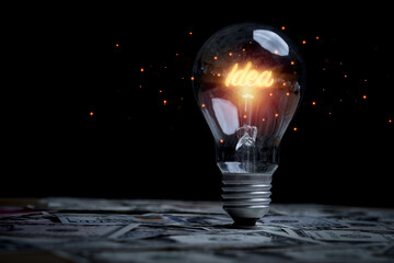 Poster - Glowing idea inside lightbulb on banknotes for creative thinking idea  and problem solving solution can make much money concept.