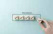 © Sandwish - Checklist and task progress tracking concept. A hand placing the final checkmark on wooden blocks in a progress bar, task completion, productivity, goal setting, and efficient project management.