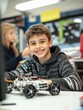 © Johannes - Happy school boy student making robotic car sitting at table at STEM class. Diverse children learning programming using computers and constructing robots at science and coding education tech lesson.