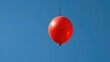 © Sourithideth - Deflated red balloon suspended in mid-air on a thin black thread, deflated balloon, isolation