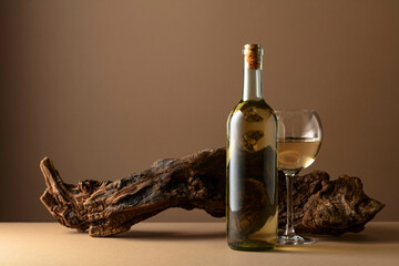 Wall Mural - White wine and old snag on a beige background.