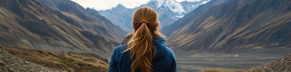 Poster - A woman with long blonde hair standing outdoors, near a mountain