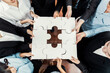 © InfiniteFlow - Top view multiethnic business people holding jigsaw pieces and merge them together as effective solution solving teamwork, shared vision and common goal combining diverse talent. Meticulous