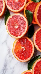 Wall Mural -   Grapefruits cut in half arranged on a white marble countertop surrounded by green foliage