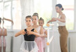 © JackF - Female teacher conduct training, performs correction of pose in first position students. Girls engaged in ballet studio, perform repetitions of elements and tasks