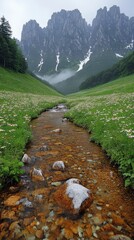 Wall Mural - Majestic Alpine Mountain Stream Landscape with Snow-Capped Peaks, Lush Greenery, Flowing Water, Wildflowers, and Misty Sky Creating a Serene Nature Scene