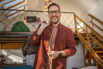 Portrait of one man happy caucasian male with travel bag at his house