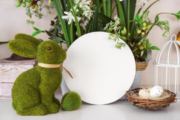 Decorative green moss bunny and blank round shape, empty circle with copy space for text and spring flowers and decorative eggs in nest. Easter holiday fesitve decor, mockup, template, background