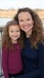 © Imagine Crane - A woman and a child are smiling for the camera. The woman is wearing a blue sweater and the child is wearing a purple sweater. Scene is happy and warm