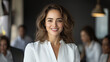 © NaphakStudio - confident woman smiles in modern office setting, showcasing professionalism and teamwork.
