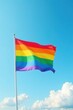 © napak - Rainbow flag billowing in a vibrant summer sky, a symbol of pride and acceptance.