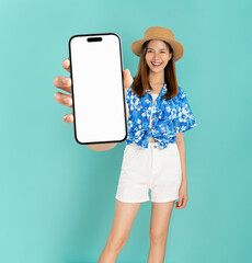 Wall Mural - Portrait of young Asian woman in summer wearing floral shirt holding and holding big smartphone mockup of blank screen and smiling on blue background.