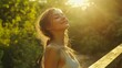 © Christian Bunge - young pretty woman stands on a bridge with her eyes closed and a smile on her face, enjoying the sun's rays, concept: take care of yourself, 16:9